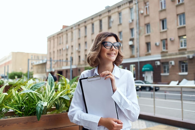 Cheerful business woman documents communication on the street