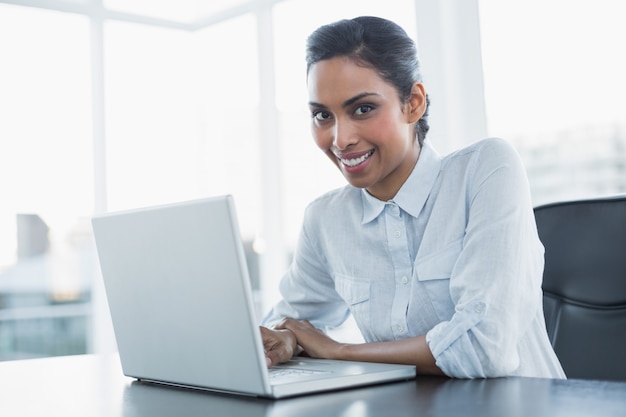 Cheerful businesswoman sitting at her desk working