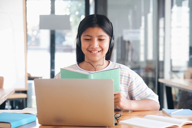 Cheerful child excited using computer for online learining. Online education and self study and homeschooling concept.