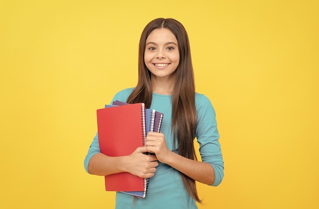 Cheerful child girl hold notepad for homework homework