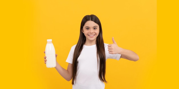 Cheerful child hold dairy beverage product teen girl going to drink milk healthy lifestyle chldhood nutrition drinking per day dairy food yogurt for breakfast kid hold milk bottle thumb up