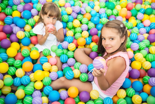 Cheerful children in playroom with plastic balls