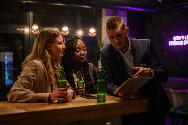 Cheerful colleagues drinking beer in the bar together after work