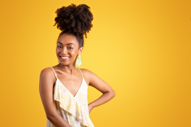 Cheerful confident young black woman in dress looks at camera enjoys vacation weekend