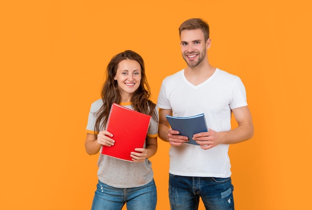 Cheerful couple hold copybook homework back to school modern education