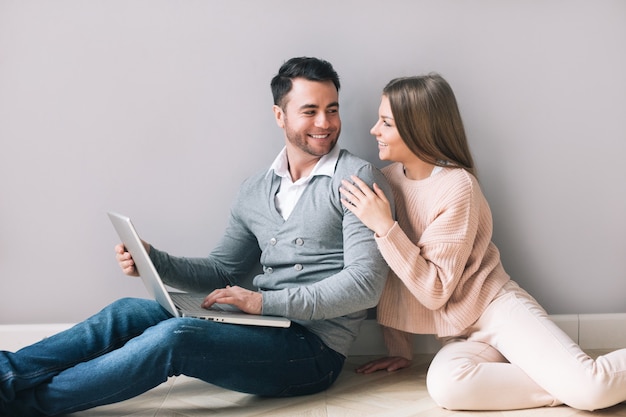 Cheerful couple with laptop at home. Online shopping.