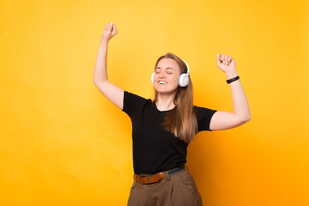 Cheerful dancing music enjoys the earphones she is wearing.