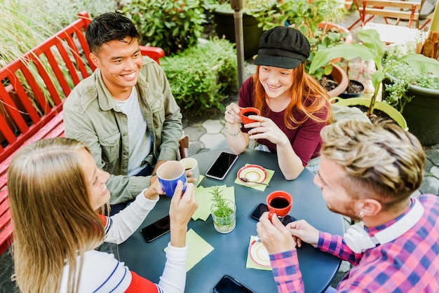 Cheerful diverse friends having breakfast outdoors