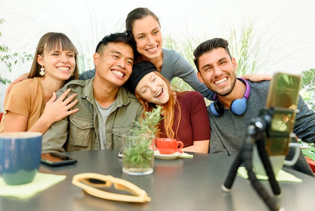 Cheerful diverse friends having video chat in cafe