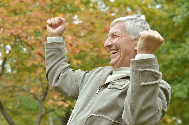 Cheerful elderly man out for a walk in the park