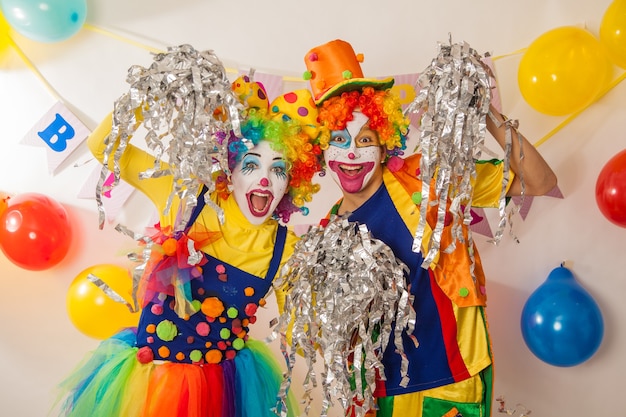 Cheerful emotional clowns at the party with paper disco