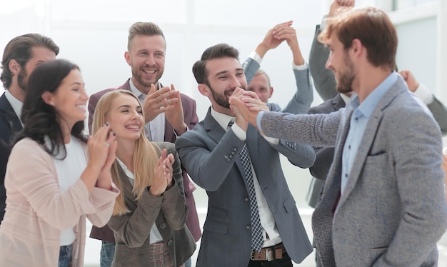 Cheerful employees congratulating a colleague on the promotion