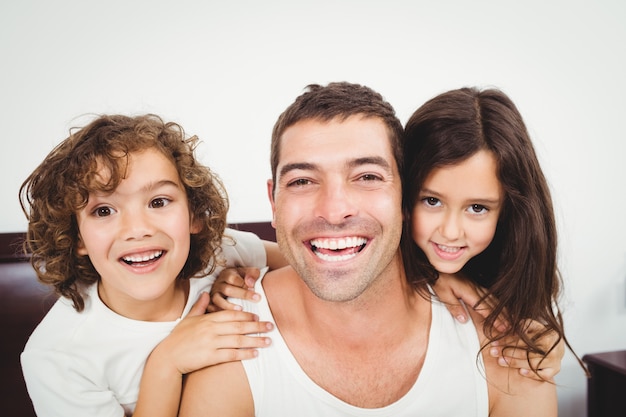 Cheerful father with daughter and son at home