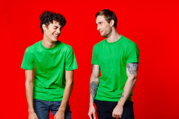 Cheerful friends in green tshirts hold on to the face of emotion