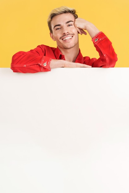 Cheerful gay man leaning on a blank board