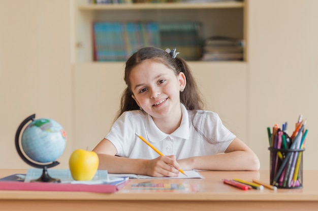 Cheerful girl looking at camera during lesson