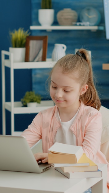 Cheerful girl looking at laptop screen for online remote classes