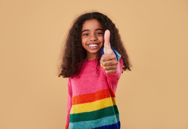 Cheerful girl showing thumb up