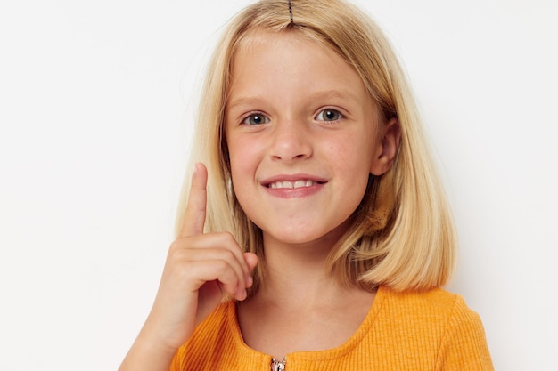 Cheerful girl in a yellow tshirt posing light background