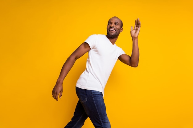 cheerful handsome african man walk wave hand look back