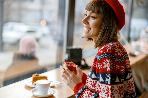 Cheerful happy and beautiful caucasian lady is resting in a cozy cafe terace