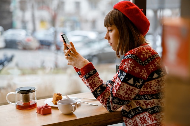 Cheerful happy and beautiful caucasian lady is resting in a cozy cafe terace