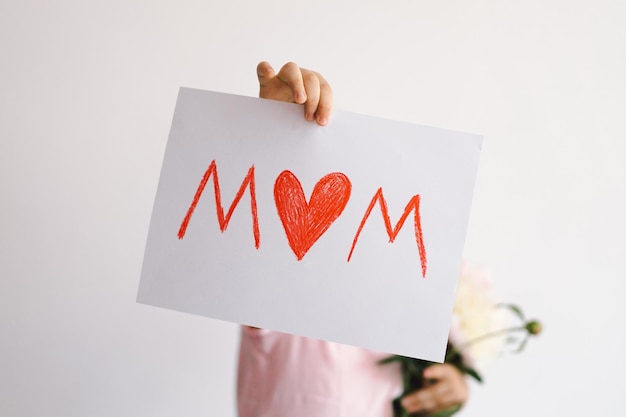 Cheerful happy child with Peonys bouquet Smiling little boy on white background Mothers Day concept