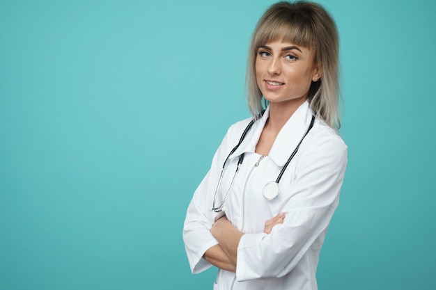 Cheerful happy doctor with crossed hands on blue background