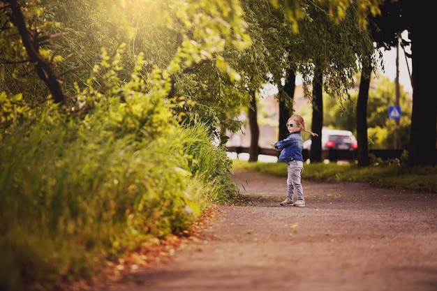 Cheerful and happy little girl with arms outstretched summer outdoors in a park smiled sweetly