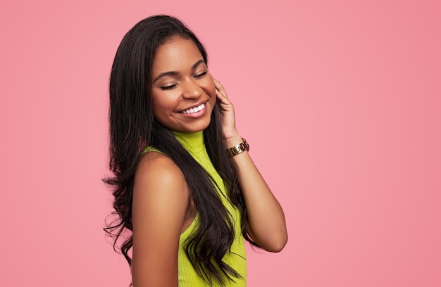 Cheerful hispanic teenager touching hair