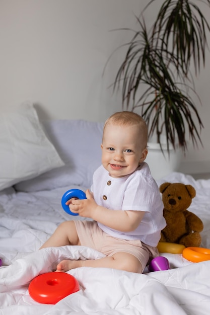 Cheerful little boy playing with toys on blanket, teddy bear, health, banner, card