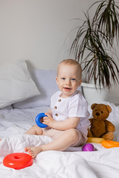 Cheerful little boy playing with toys on blanket, teddy bear, health, banner, card