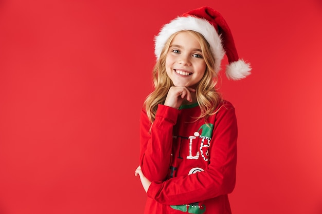 Cheerful little girl wearing Christmas costume standing isolated, looking