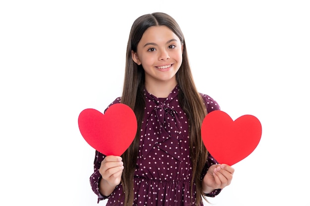 Cheerful lovely romantic teen girl hold red heart symbol of love for valentines day isolated on white background Portrait of happy smiling teenage child girl