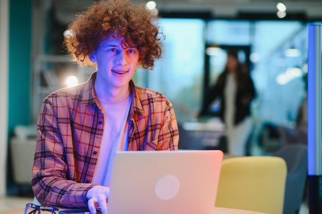 Cheerful male freelancer browsing funny video content while networking in social media using netbook technology in street cafe happy hipster guy enjoying free time for online blogging via laptop