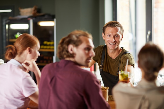 Cheerful Man Enjoying Lunch with Friends in Cafe