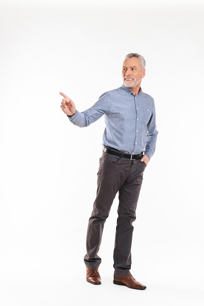 Cheerful man pointing aside with hand and smiling isolated