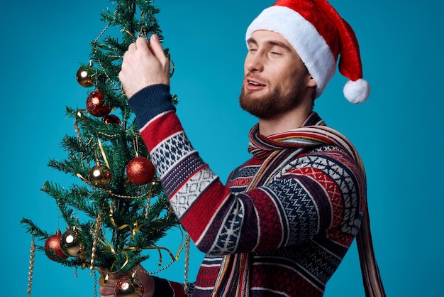 Cheerful man in a santa hat holding a banner holiday blue background