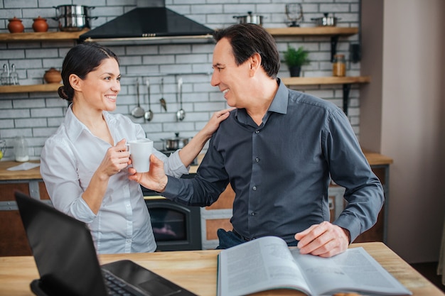 Cheerful man and woman are together in kitchen.