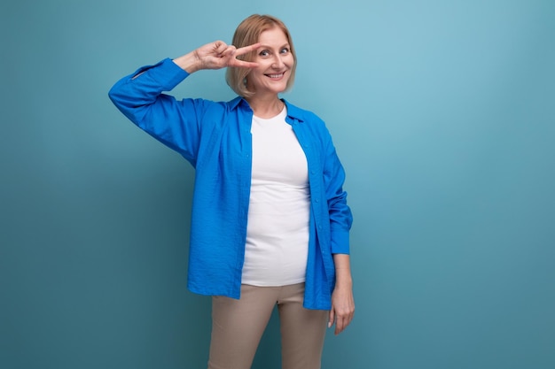 Cheerful mature woman in an attractive image on a blue background with copy space