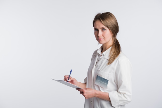 Cheerful medical doctor woman taking notes.