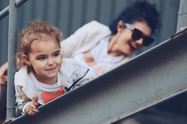 Cheerful mother and daughter having fun in city