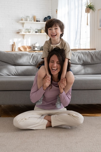 Cheerful mother give piggyback ride to laughing child cheerful parent happy spend weekend with kid