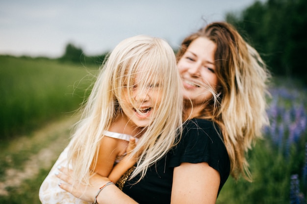 Cheerful mother have fun with her little daughter at nature