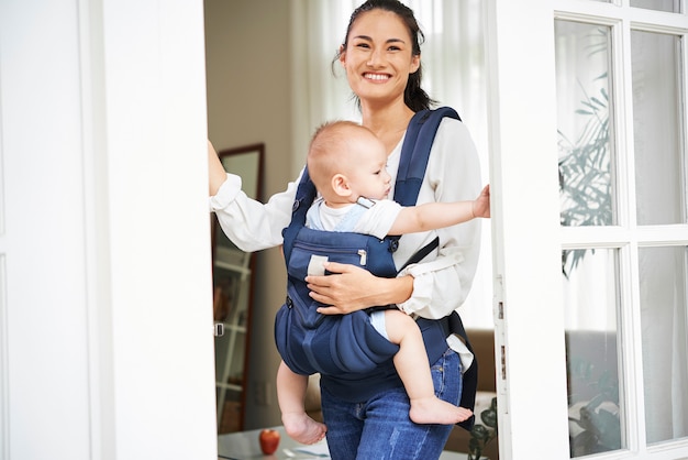 Cheerful mother opening front door