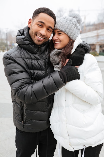 Cheerful multiethnic young couple standing together outdoors