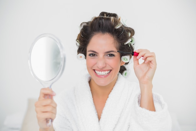 Cheerful natural brunette holding mascara