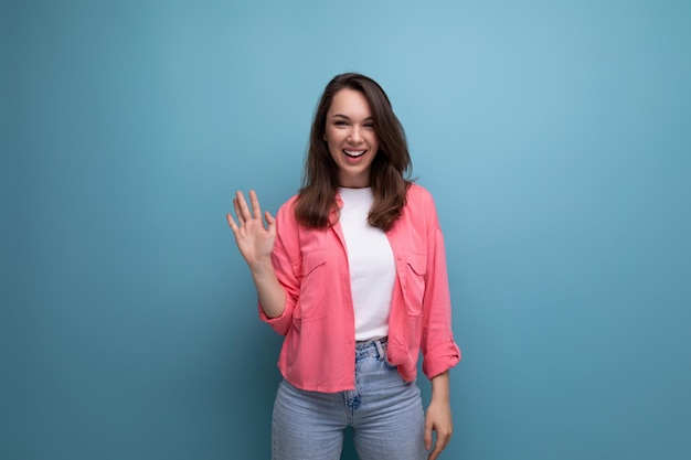 Cheerful positive brunette young female adult in a shirt with joyful emotions on an isolated