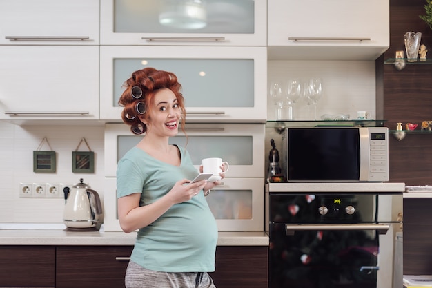 Cheerful pregnant woman using a smartphone