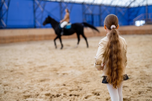 Cheerful pretty child on countryside Young cute girl on a horse ranch